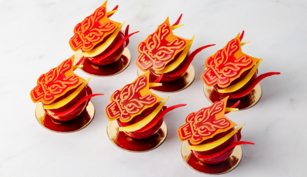 Prosperous dragon macarons flavoured with jasmine, mandarin and almond to symbolise luck, and are adorned with a gold dragon stencil, thought to bring wealth, prosperity and good fortune for the coming year. 